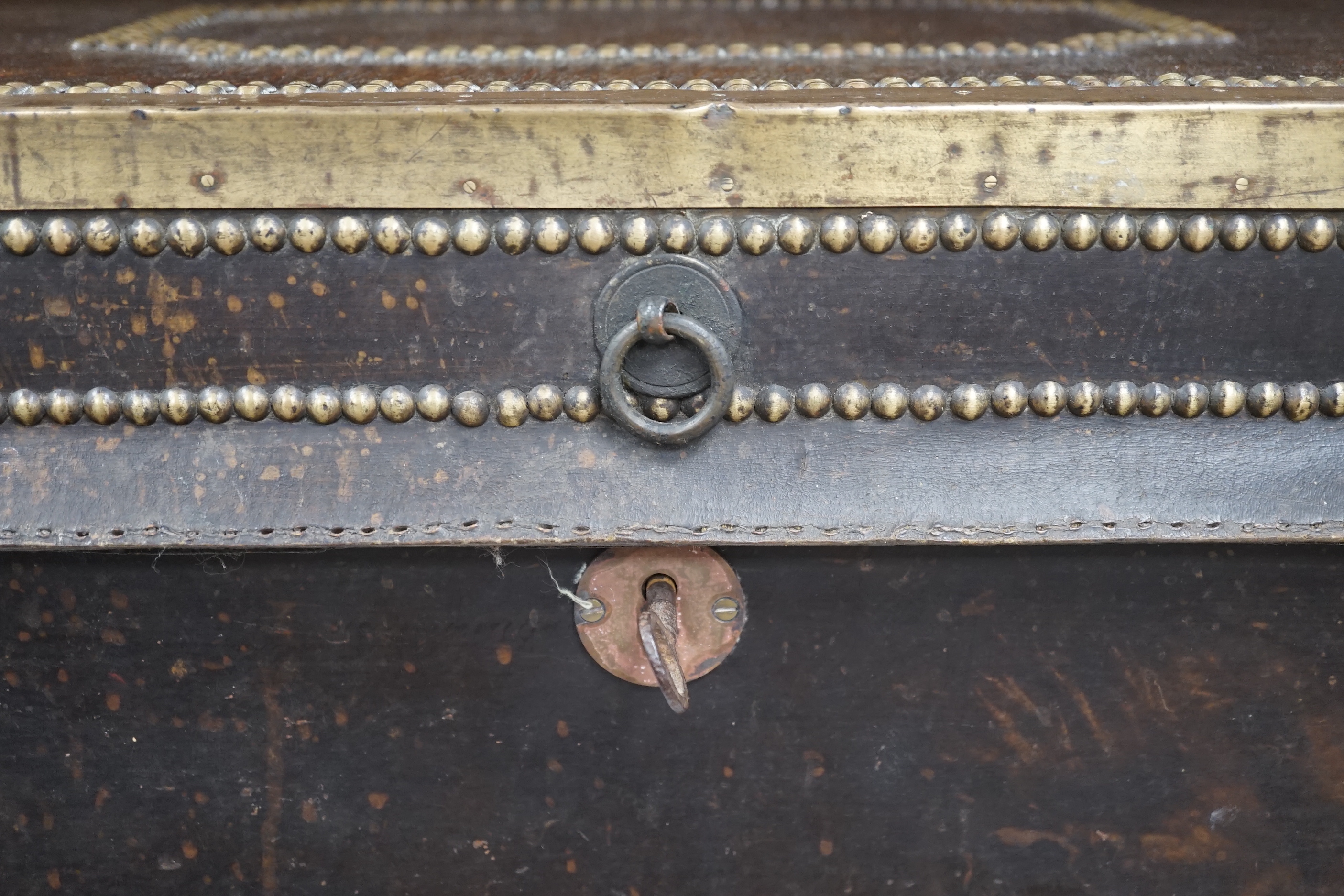 A 19th century leather and brass studded and mounted travelling trunk with metal and printed paper lining, 73.5 cm wide x 33cm high x 39cm deep